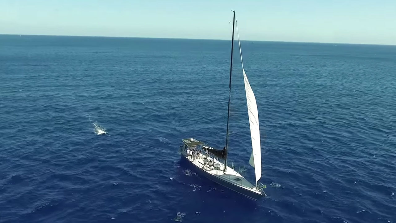 Small AI camera mounted on sailboat mast scanning ocean waters for plastic debris