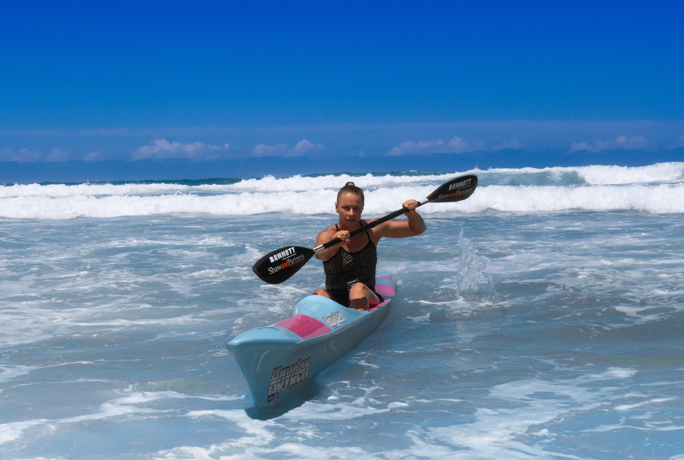 Bonnie Hancock paddling a surf ski through ocean waves at the Maroochydore competition