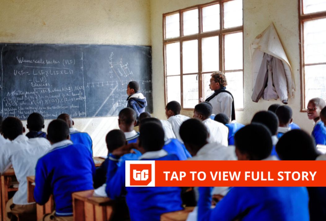 African teacher working with young students on reading lesson in bright classroom setting