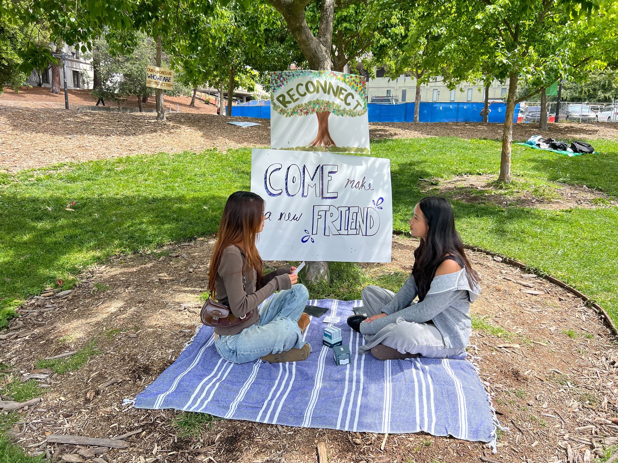 UC Berkeley students playing volleyball on grass during phone-free campus gathering with handmade signs