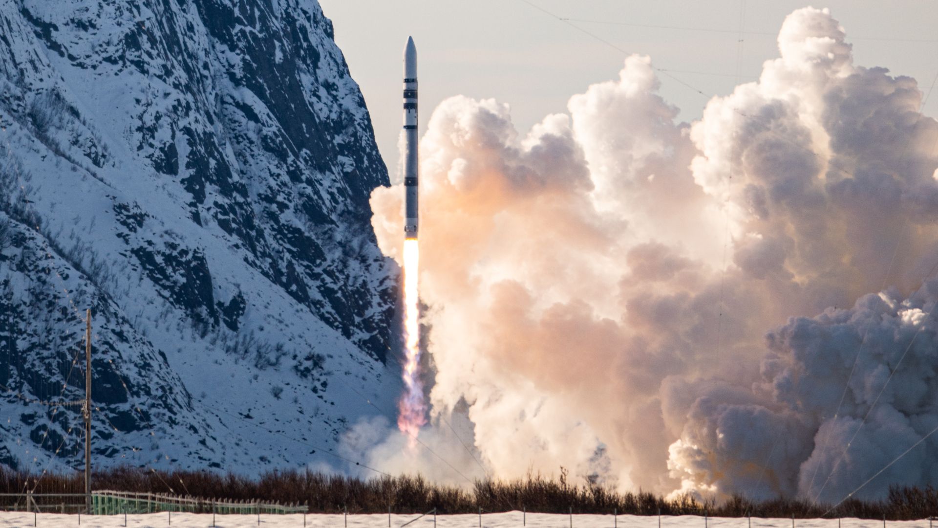 German Spectrum rocket launching from snowy Norwegian spaceport with bright exhaust flames
