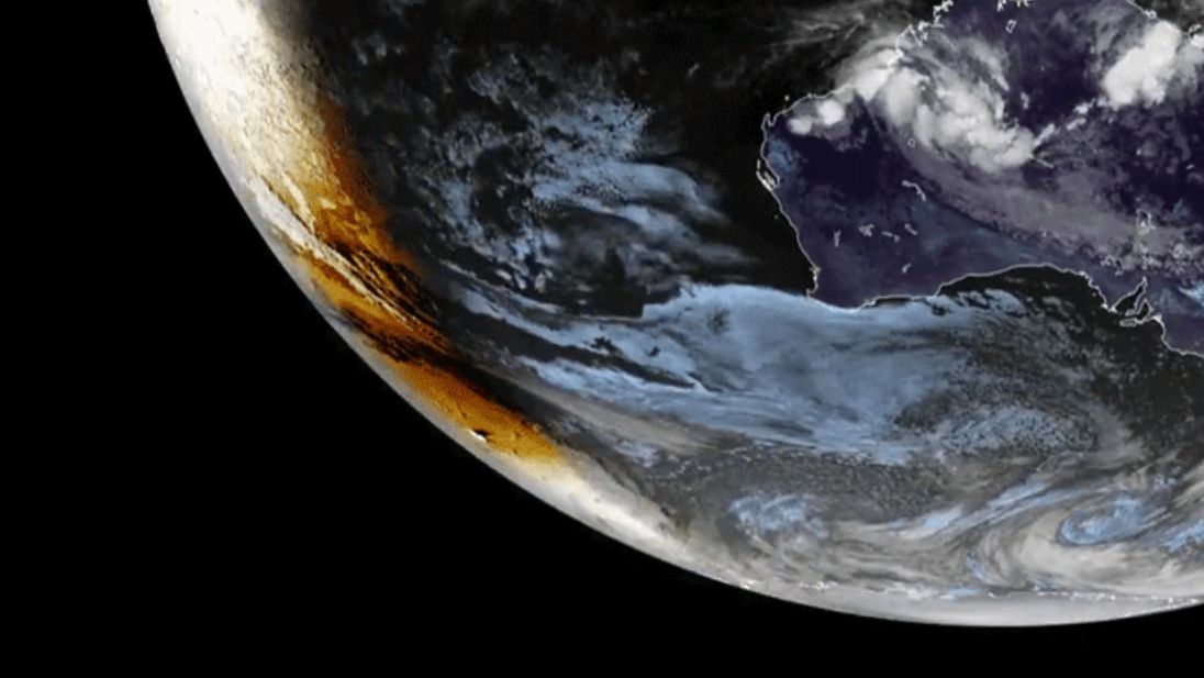 Satellite view of moon's dark circular shadow moving across snow-covered Antarctic landscape during solar eclipse