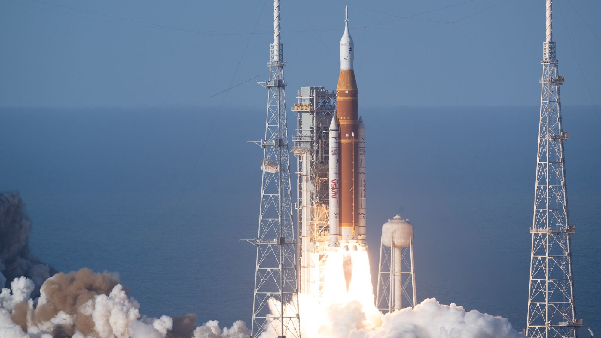 NASA's Artemis 2 mission launching from Kennedy Space Center with bright flames illuminating the night sky