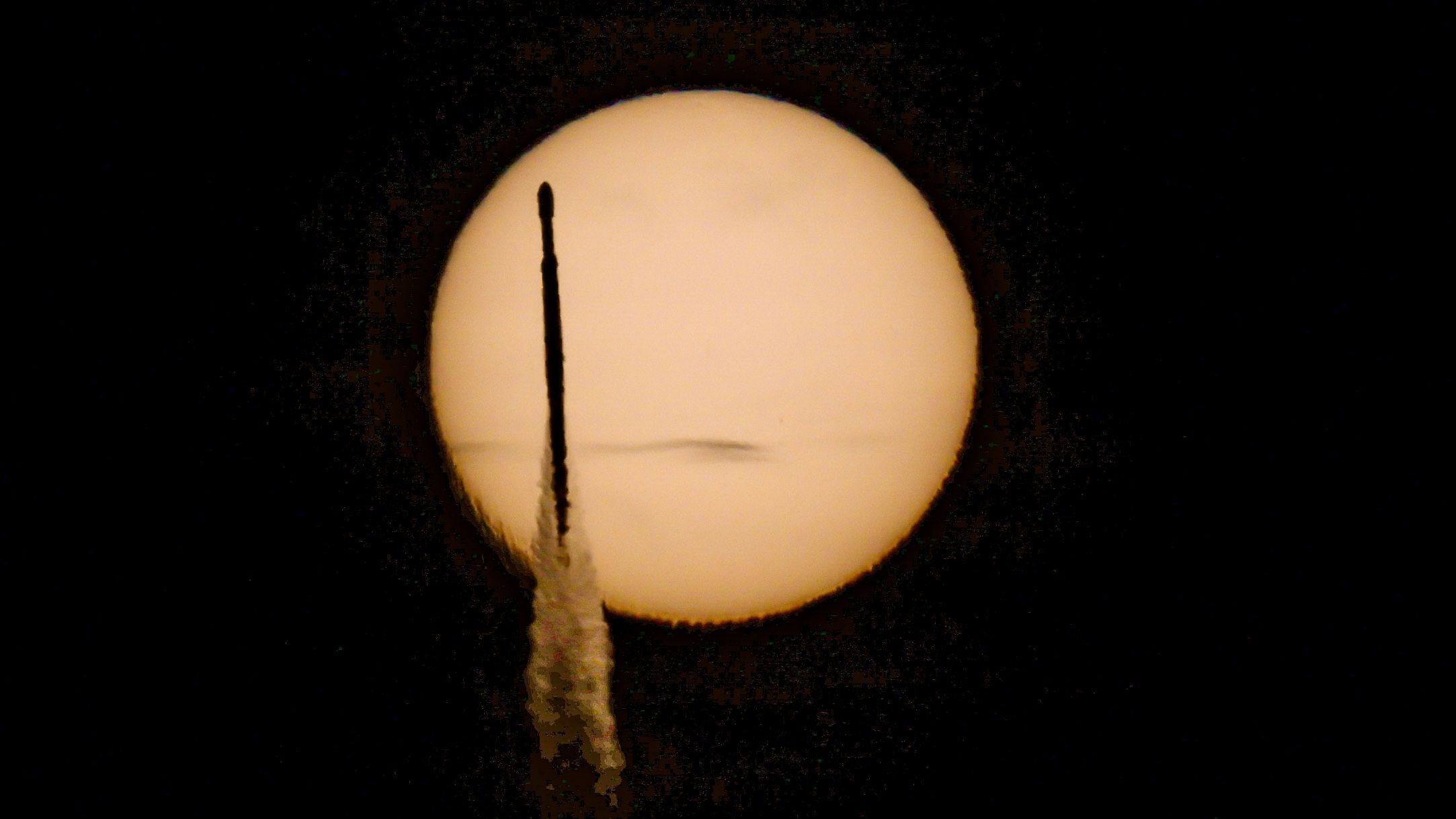 SpaceX Falcon Heavy rocket silhouette crossing sun during NASA telescope launch from Florida