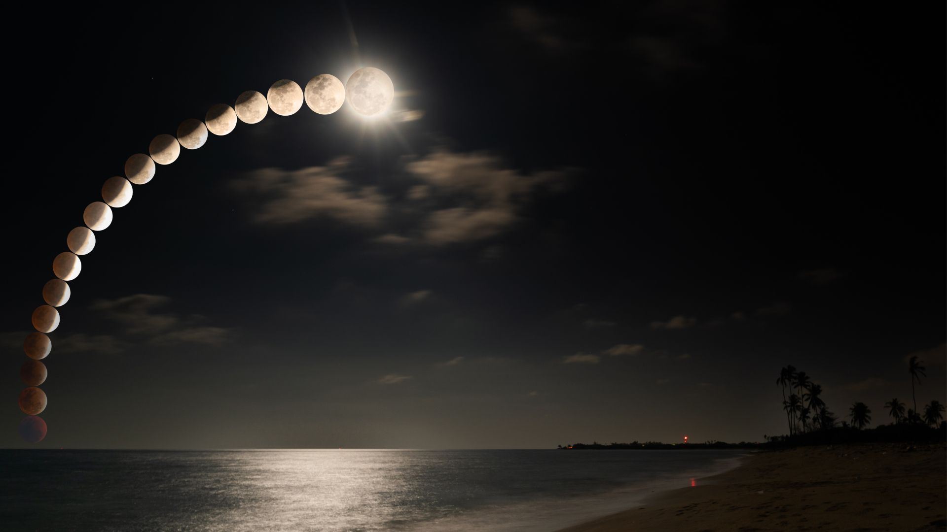 Orange-red blood moon rising over South China Sea during total lunar eclipse in Malaysia