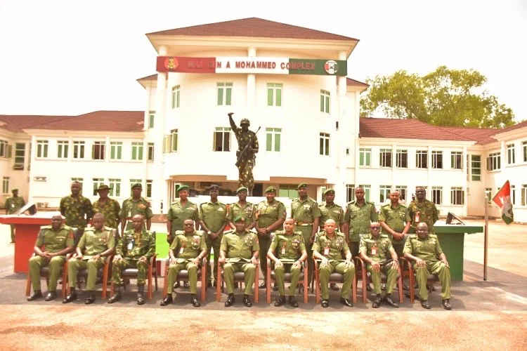 ** Nigerian military commander presenting gifts to retiring soldiers in uniform at farewell ceremony