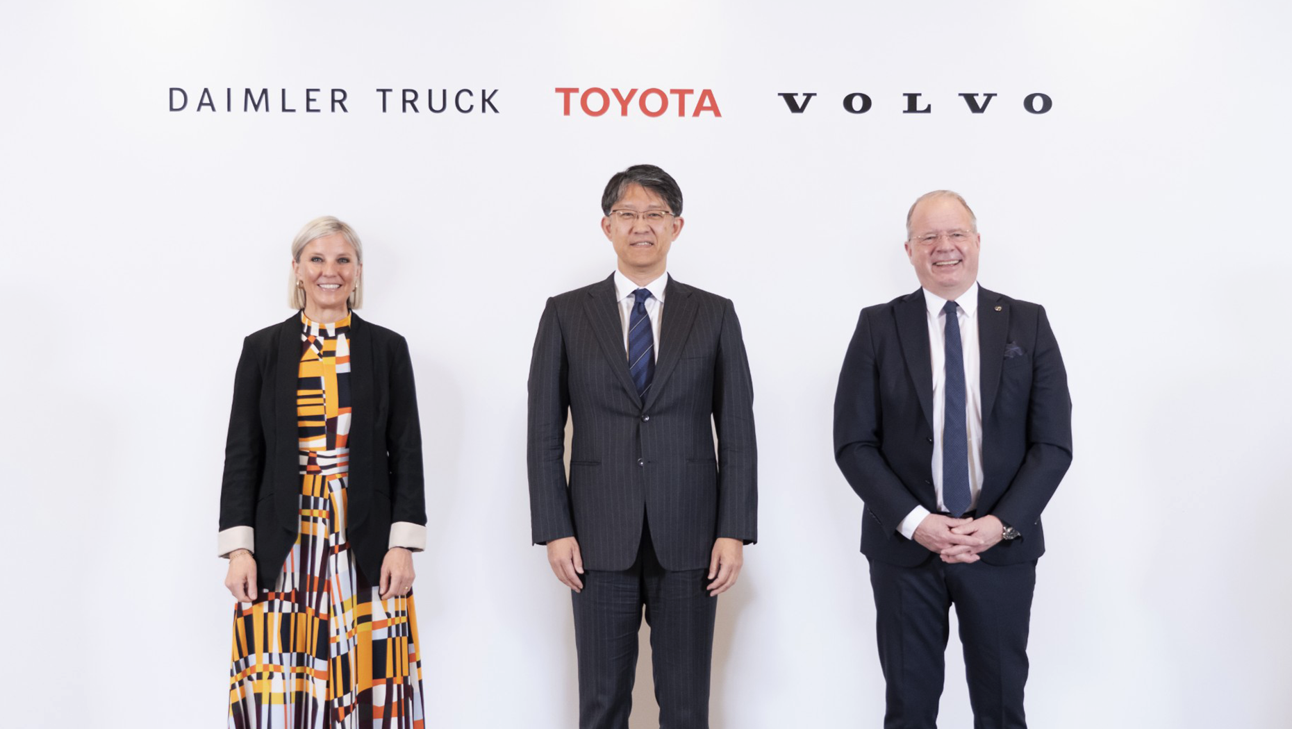CEOs of Toyota, Volvo Group, and Daimler Truck standing together at partnership announcement