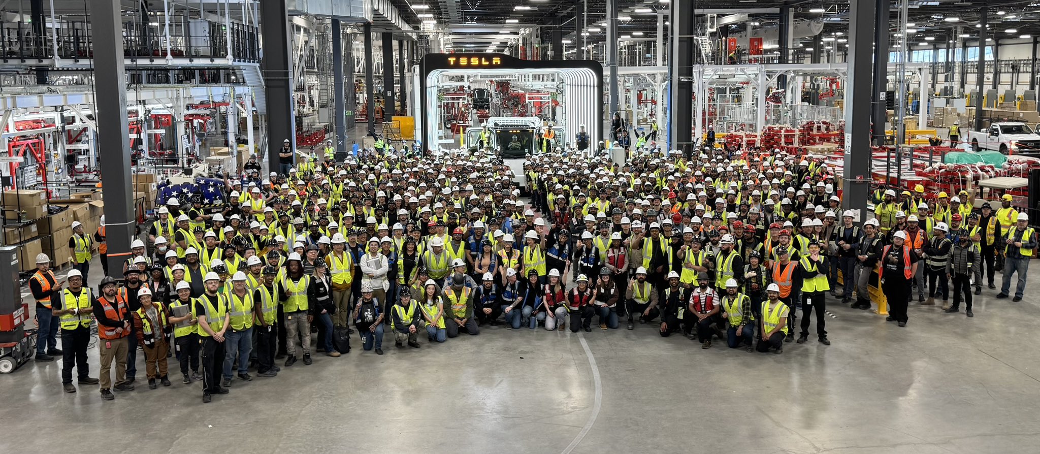 Hundreds of Tesla employees gathered around the first Semi truck from their mass production line