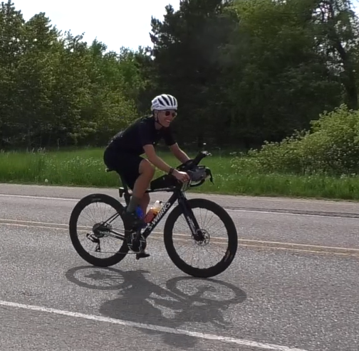 Cyclist Lael Wilcox riding bicycle on road during her around-the-world record attempt