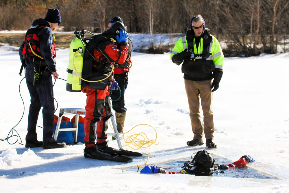 Fort McCoy firefighters in dive gear conducting ice rescue training at Big Sandy Lake Wisconsin