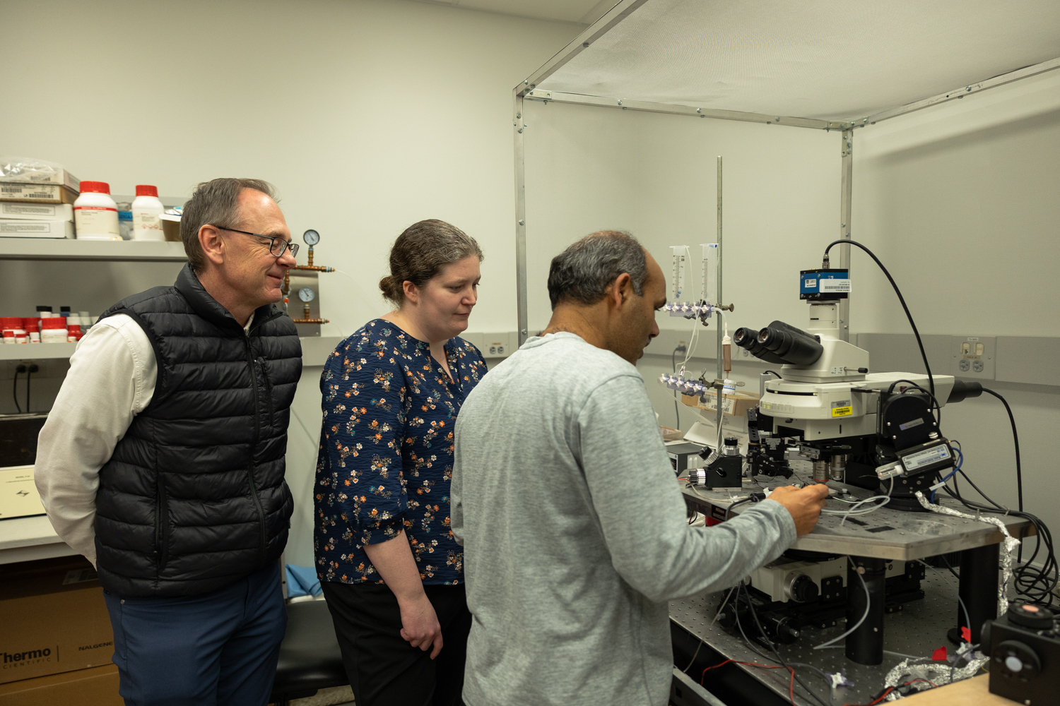 Researchers examining microscope slides in University of Iowa medical laboratory studying brain addiction pathways