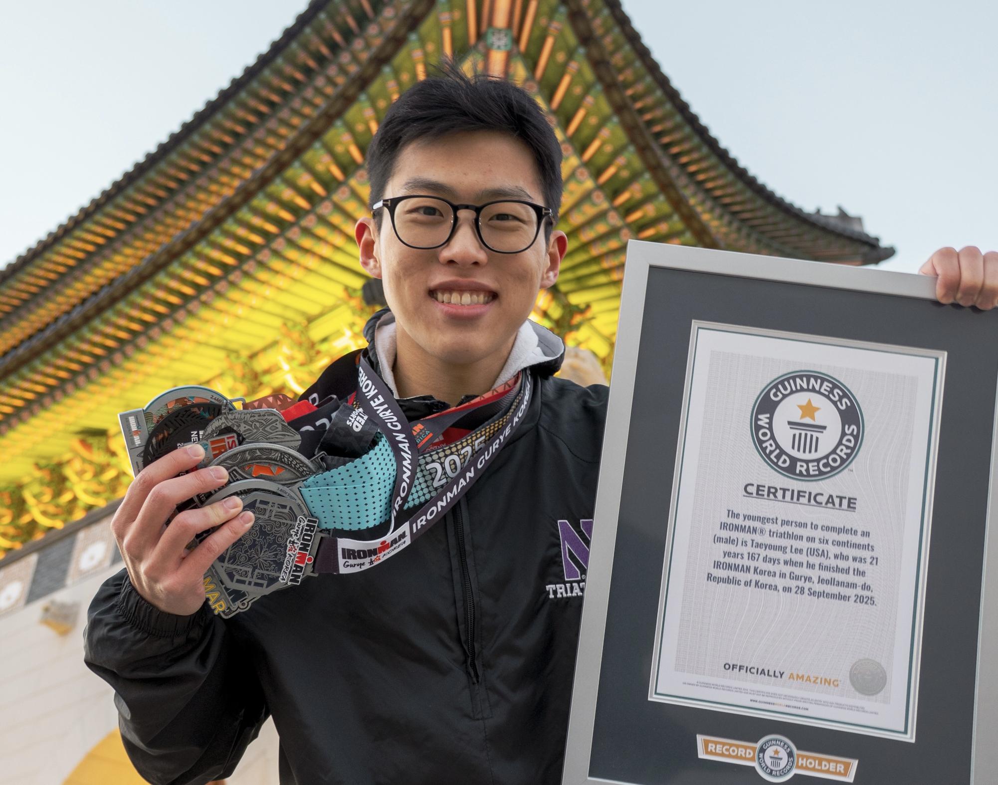 Taeyoung Lee holding up six fingers at Ironman triathlon finish line celebrating world record