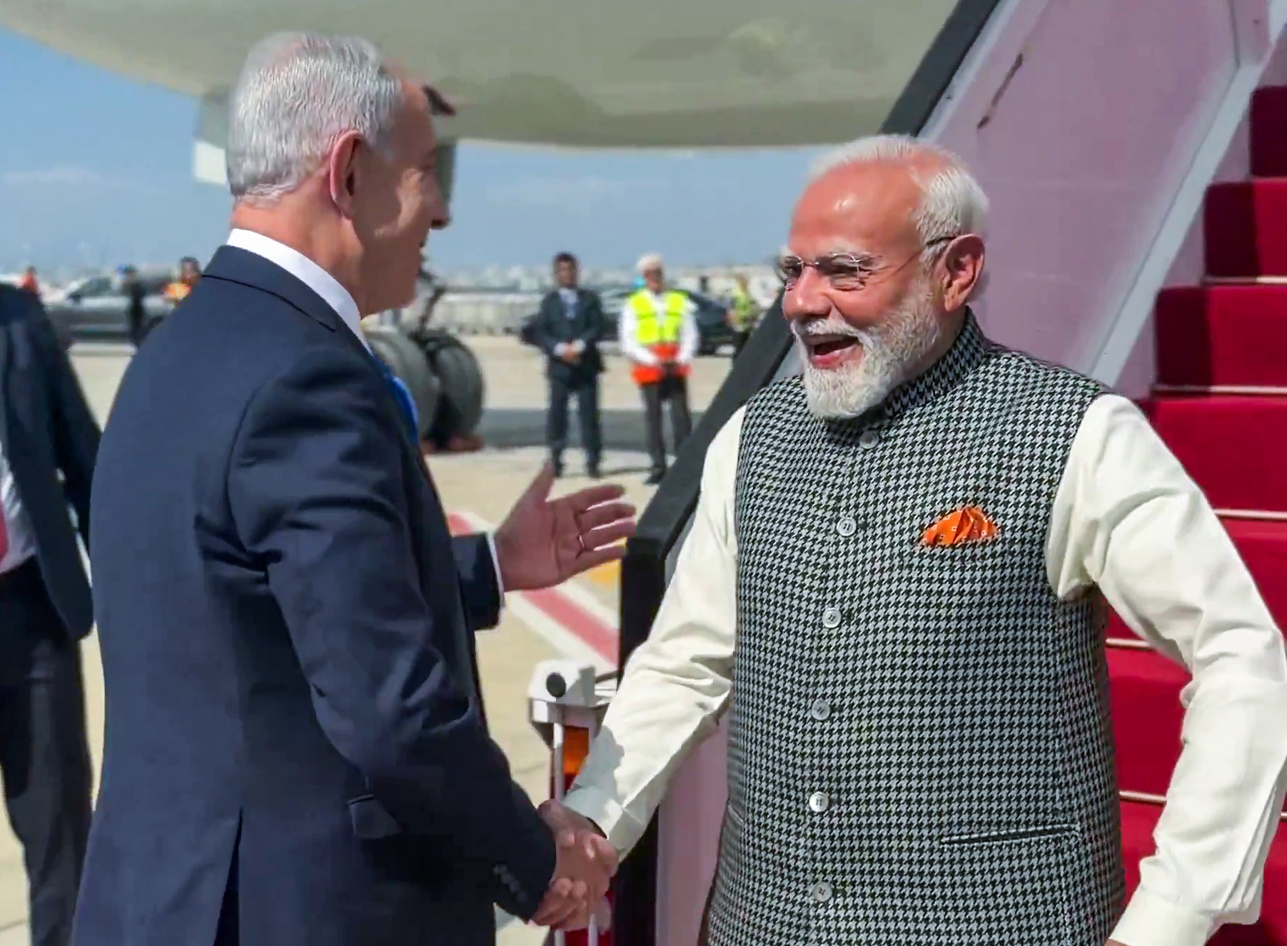 Indian and Israeli flags with farmers working in modern agricultural fields using advanced technology