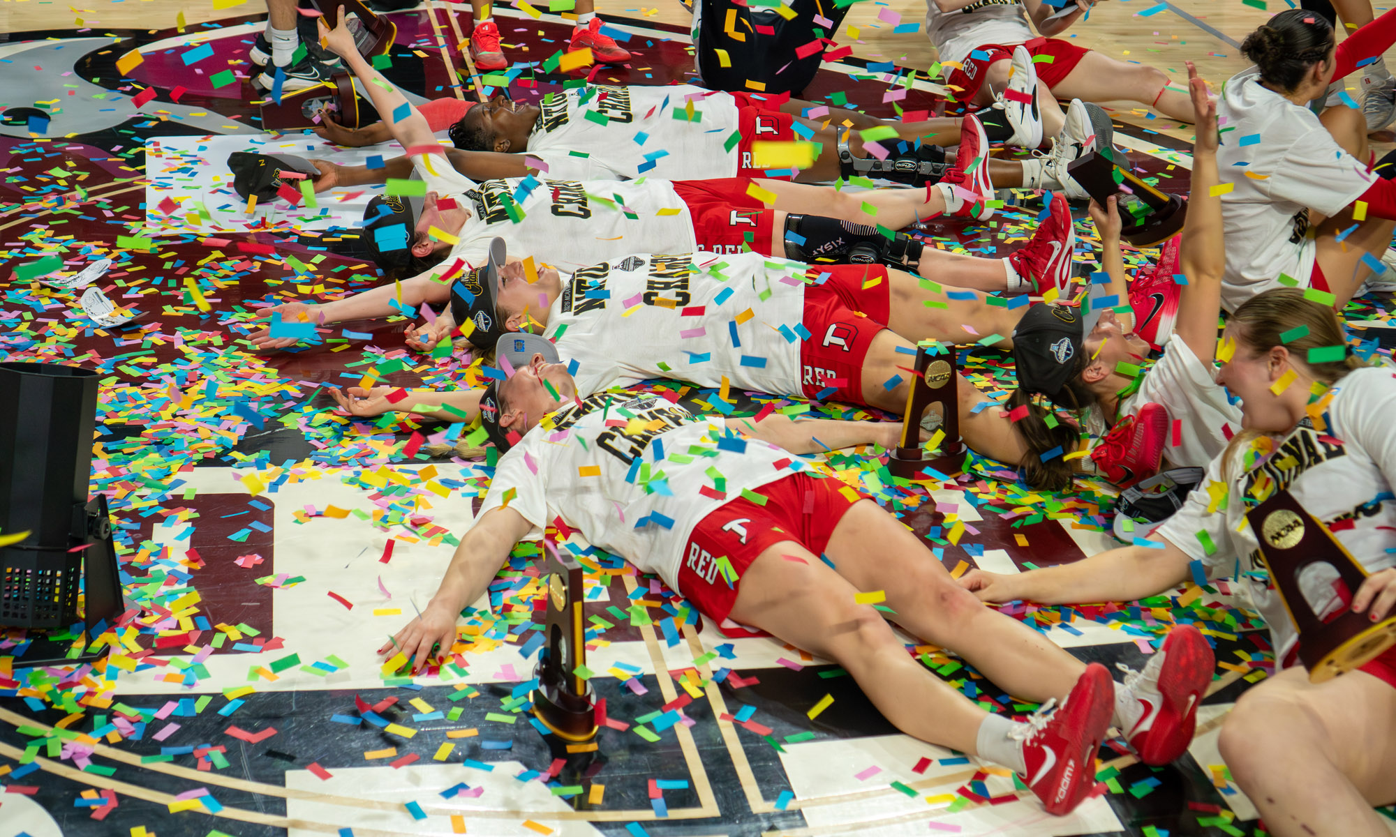 Denison University women's basketball and men's swimming teams celebrating NCAA championship victories with trophies
