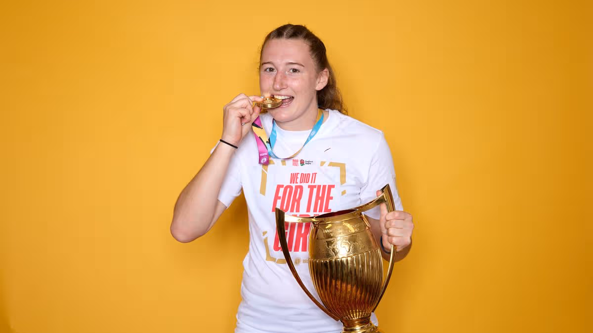 Emma Sing holding the Women's Rugby World Cup trophy in England jersey