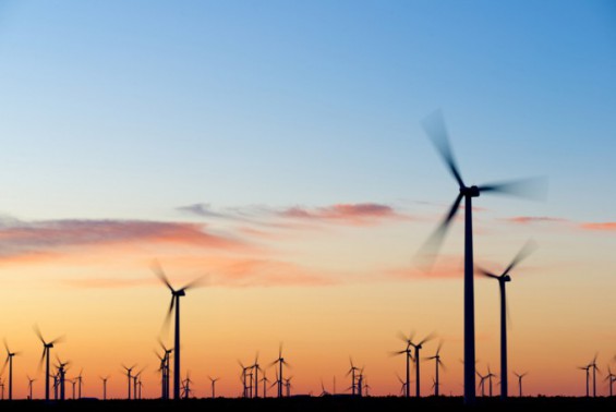 Solar panels and wind turbines generating clean renewable electricity under bright blue sky