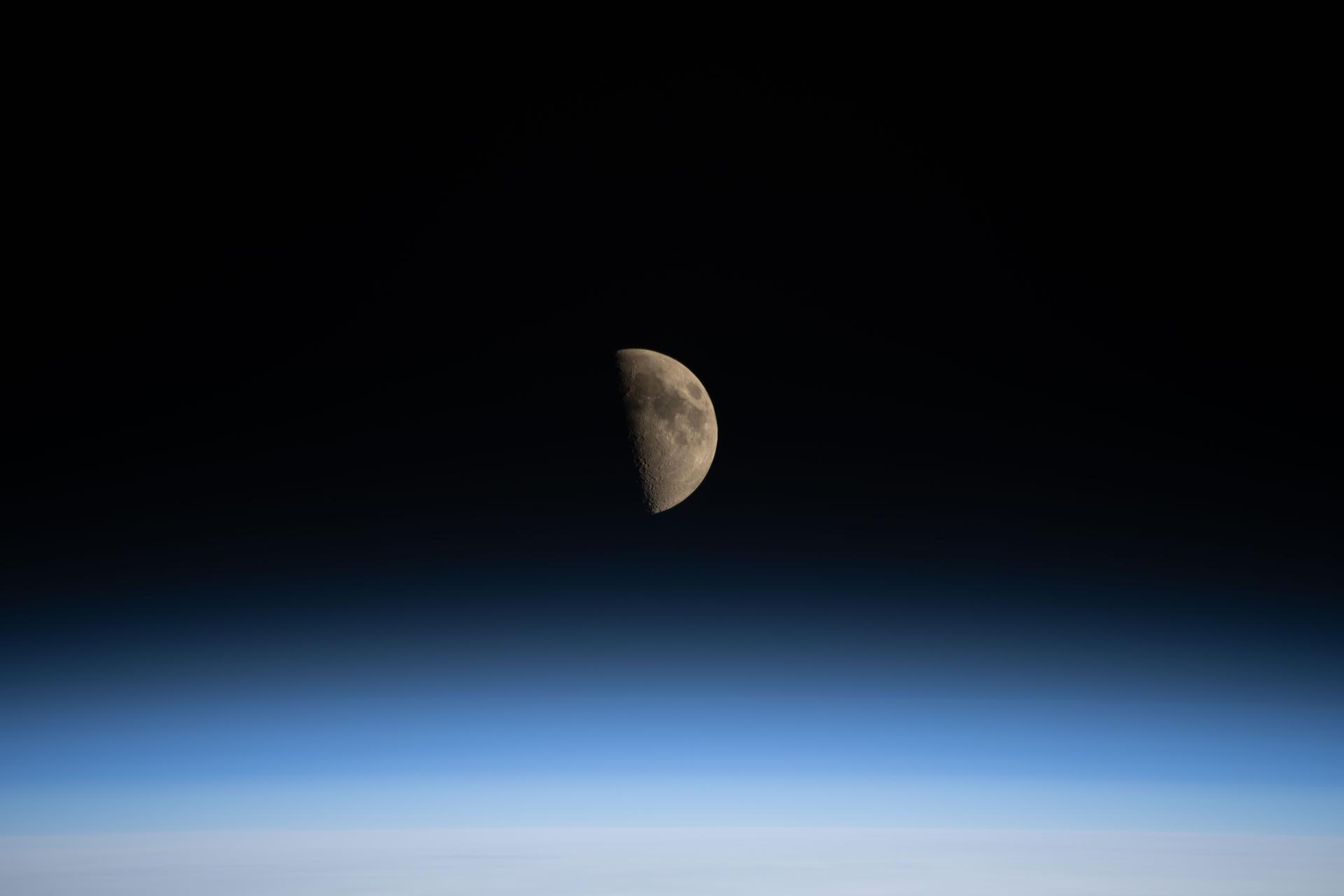 ** NASA's Space Launch System rocket and Orion spacecraft on launch pad with Moon rising behind