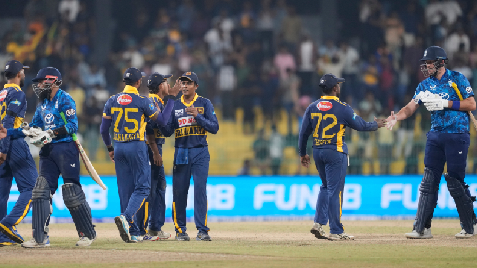 ** Sri Lankan cricket team players celebrating together after defeating England in Colombo ODI match
