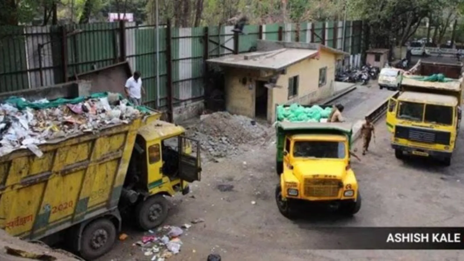 ** Municipal waste collection vehicles lined up on Gurugram city street ready for deployment
