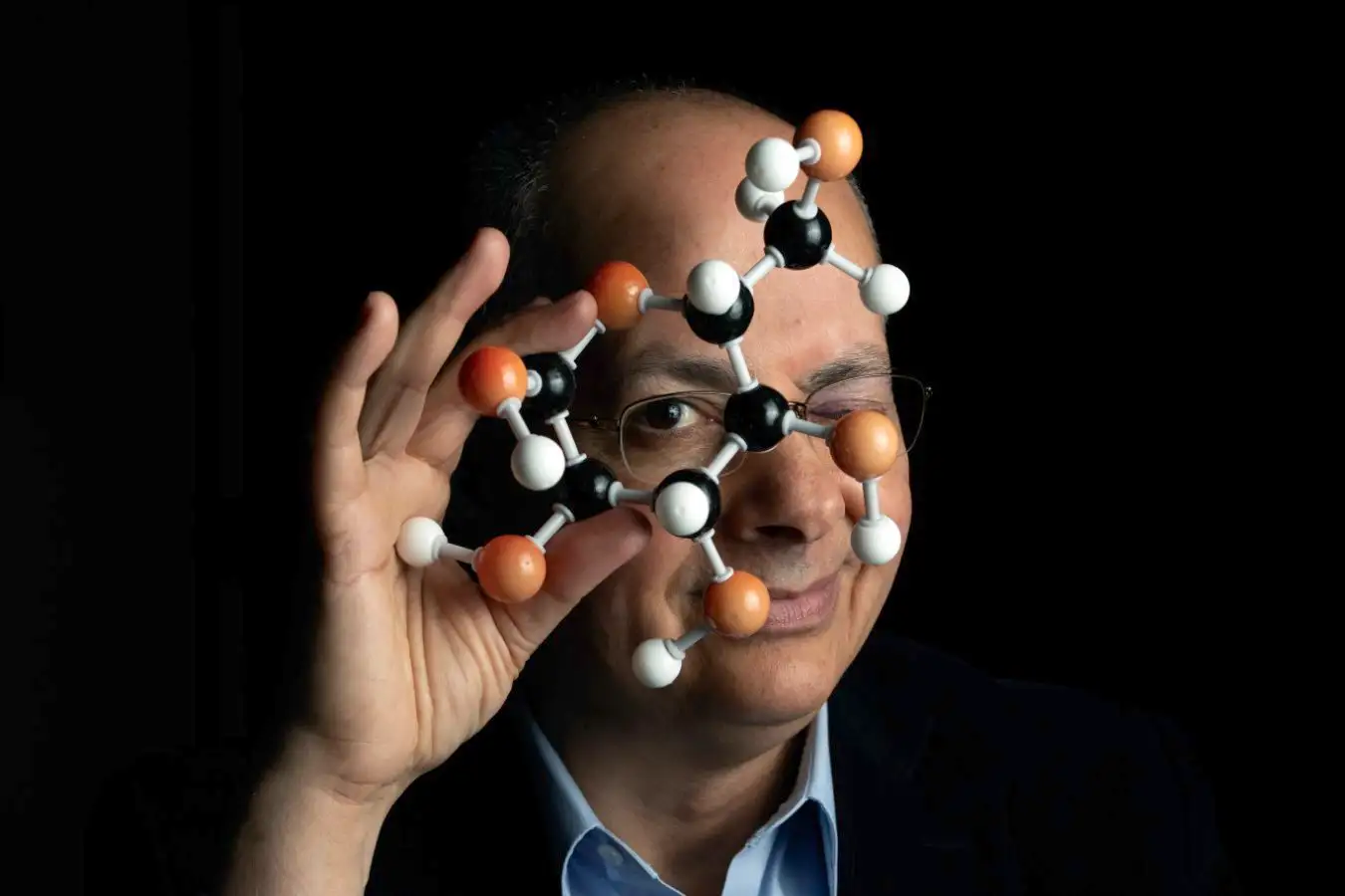 Omar Yaghi standing in laboratory with crystalline metal-organic framework materials used for water harvesting