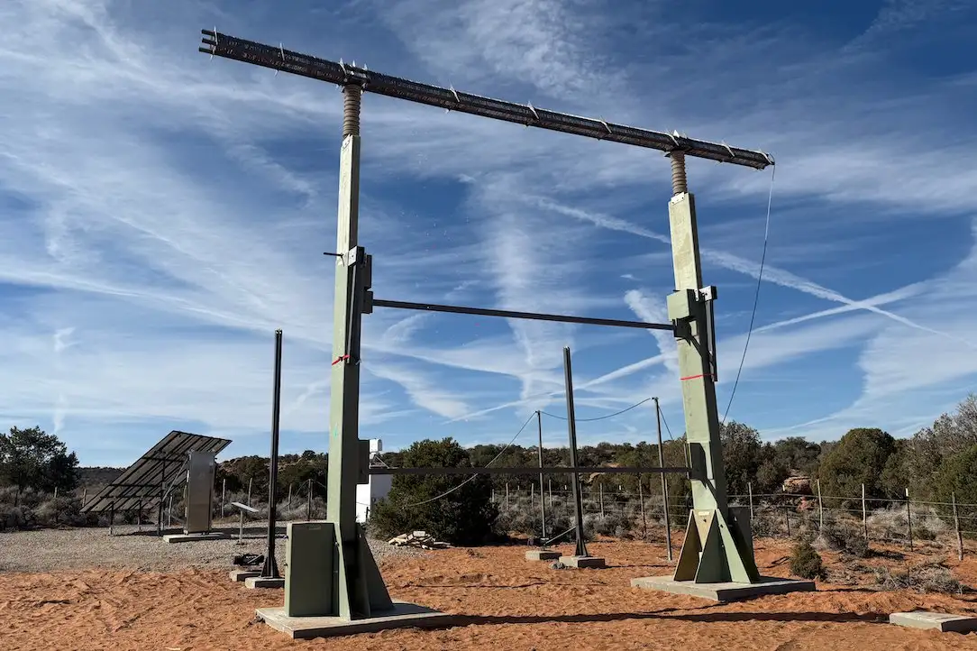 Two tall metal pylons with wire between them standing in snowy Utah mountains