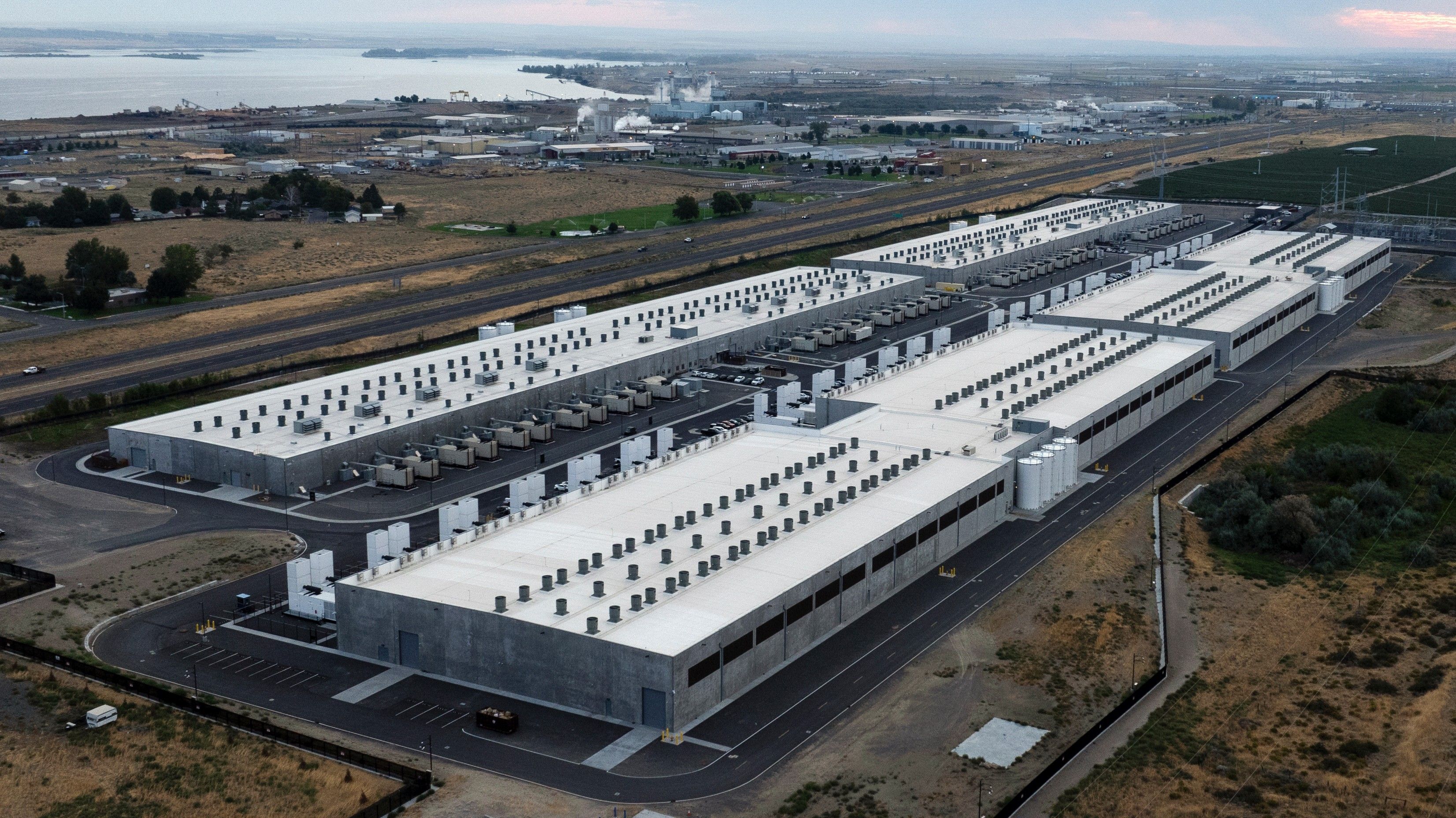 Solar panels and wind turbines generating clean energy near modern data center facility