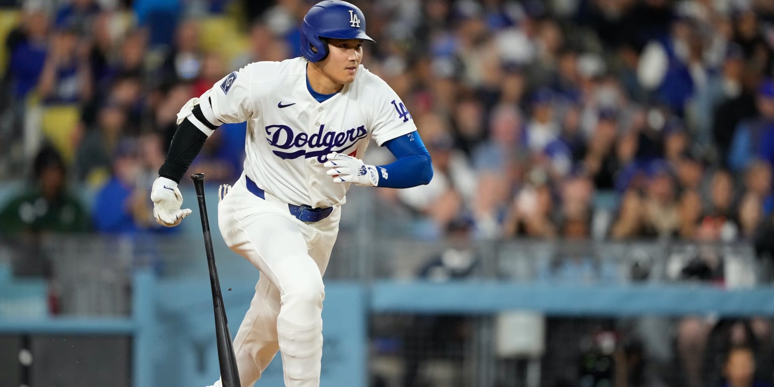 Shohei Ohtani in Dodgers uniform celebrating after reaching base during historic streak