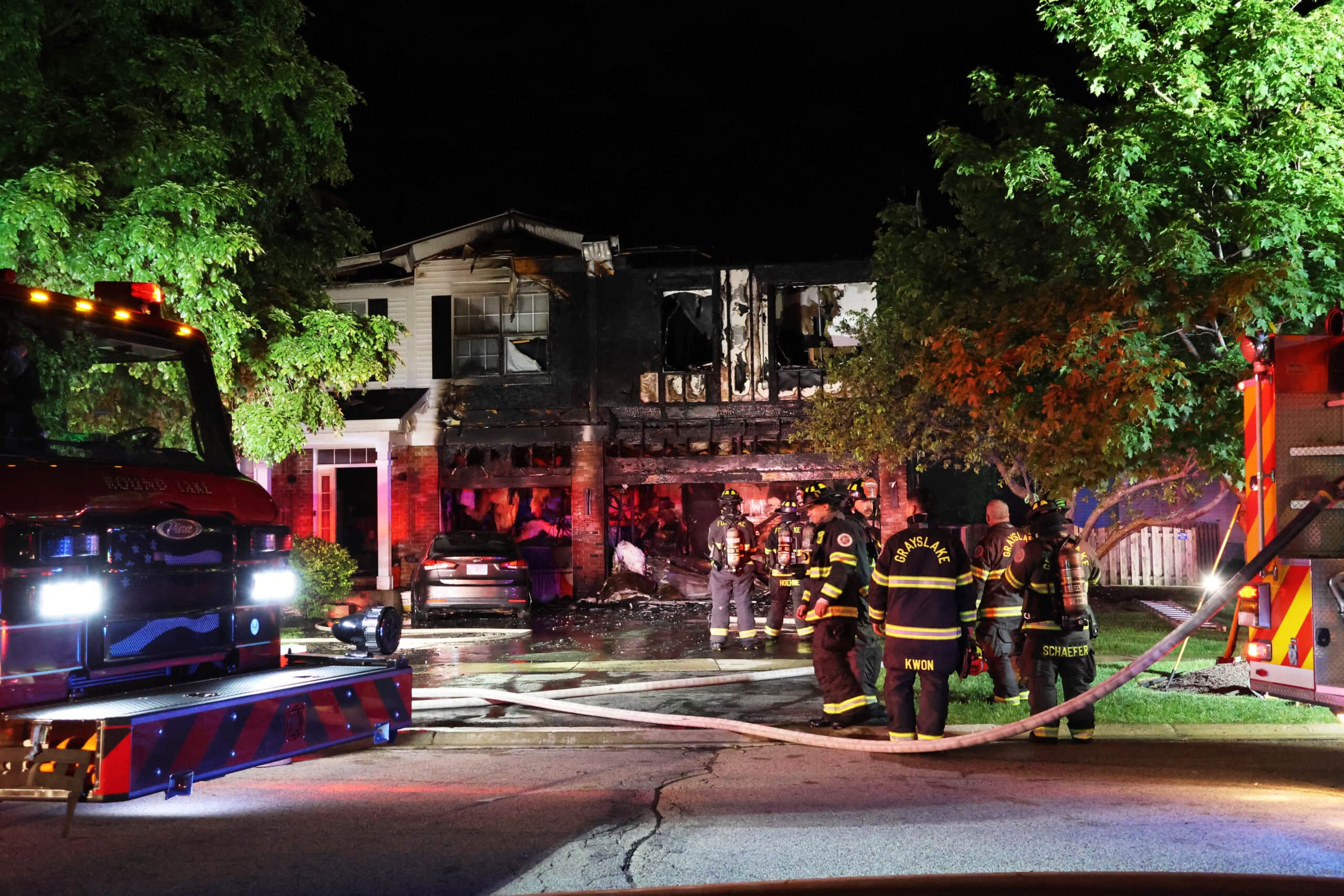 Firefighters on ladder truck spray water on two-story house fire in Round Lake