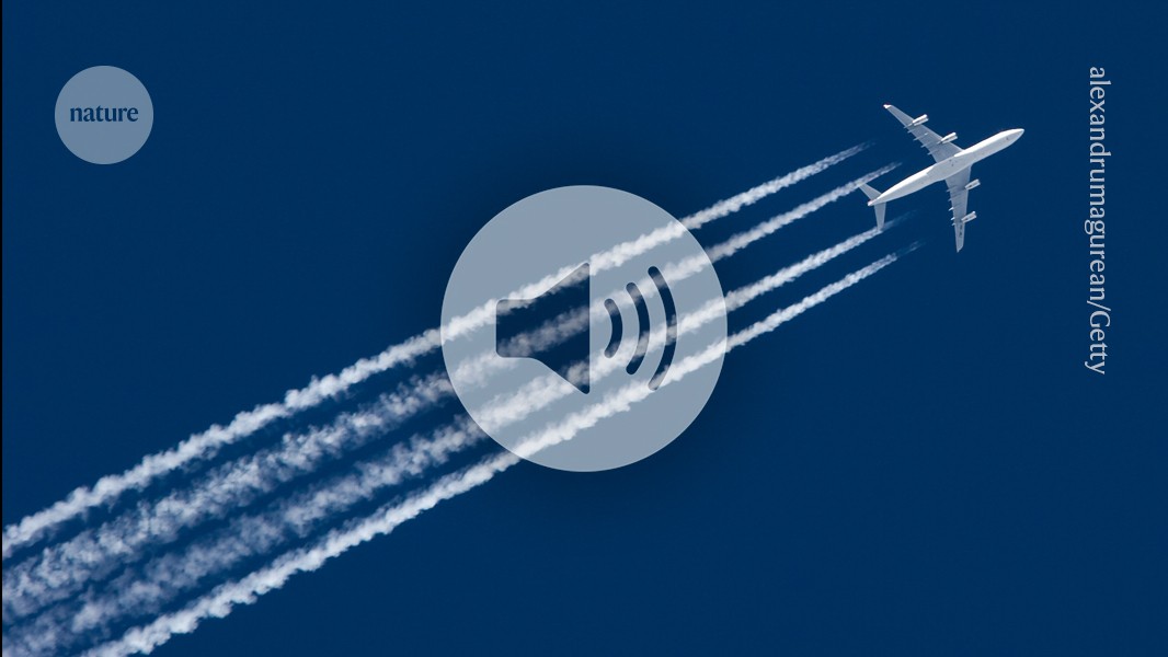 Research aircraft flying through white contrails behind commercial jet at high altitude