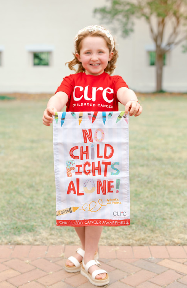 ** Young Augusta artist Banks Johnson holding garden flag featuring her colorful artwork design