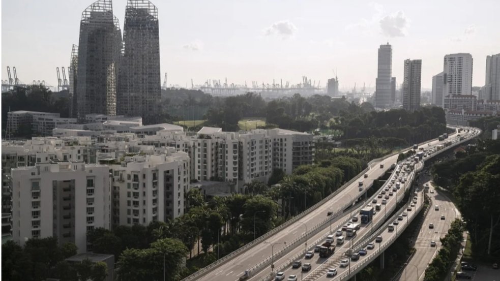 Traffic flowing smoothly on Singapore's West Coast Highway with modern city skyline in background