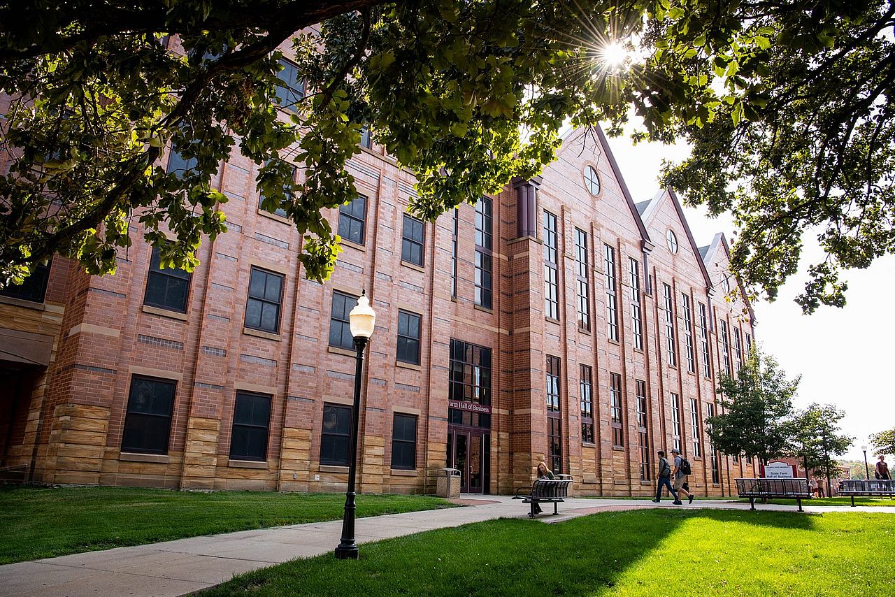 Two college students celebrating scholarship award at Illinois State University's business school building