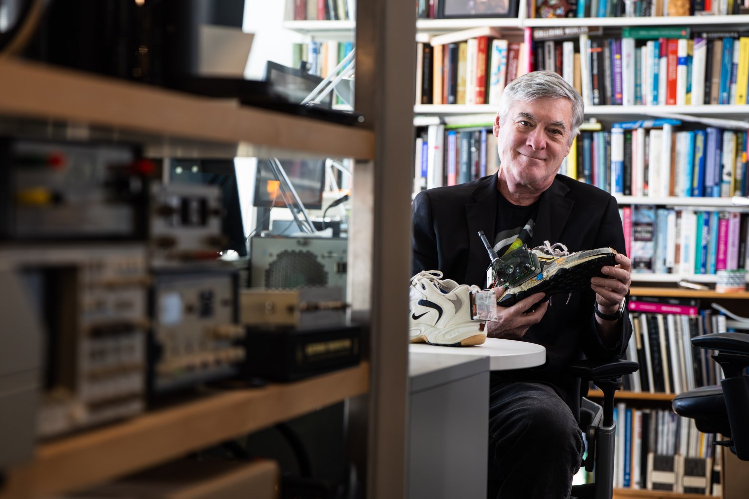 MIT Professor Joseph Paradiso holding an electronics-embedded sneaker prototype in his office