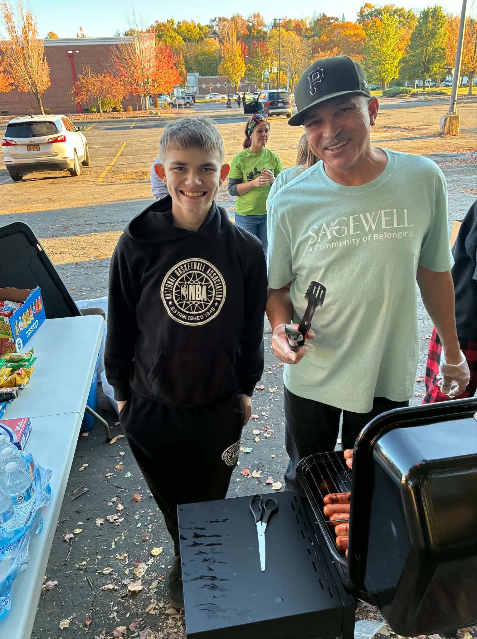 Eighth-grader Jayden Walters and staff member Billy Torres serving meals to community members in Jamestown