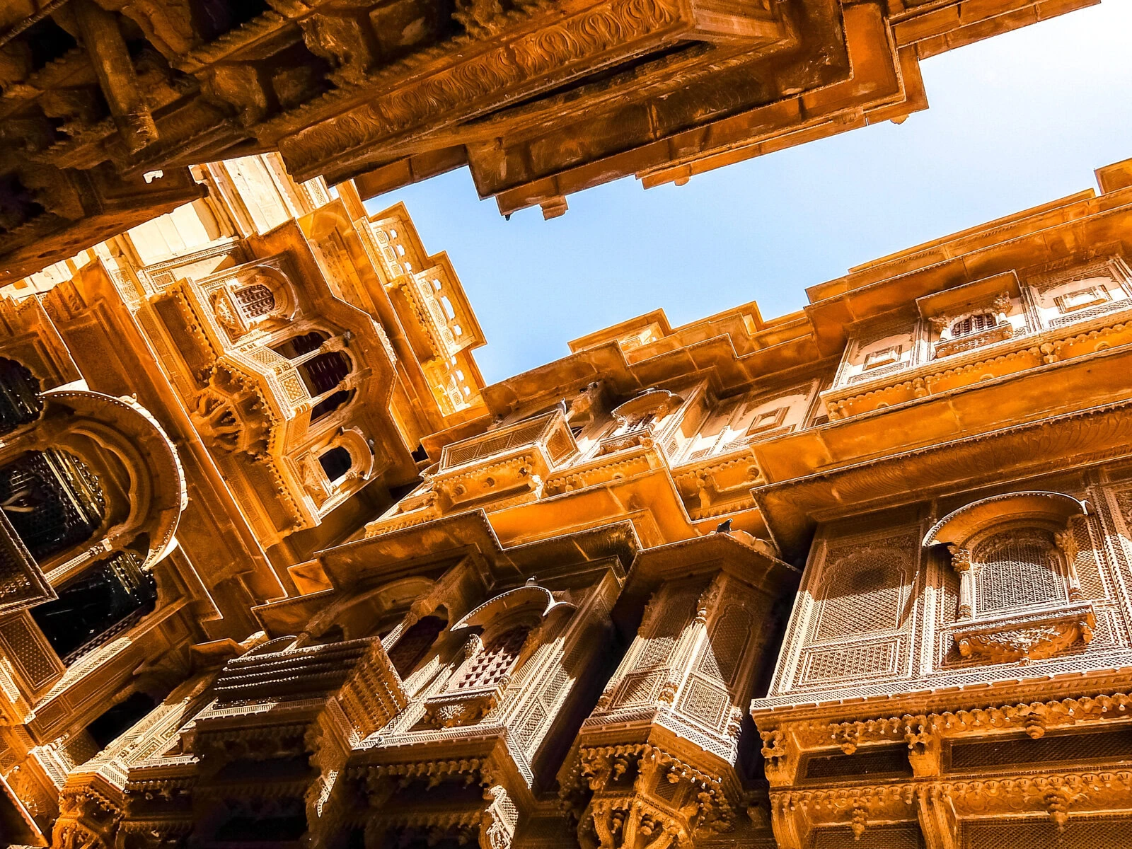 Person walking through ornate stone gates of historic Fort of St Jerome in India