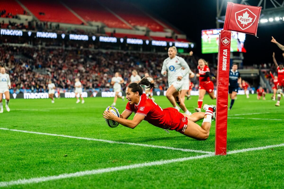** Canadian women's rugby players celebrating victory before packed crowd at Toronto's BMO Field stadium