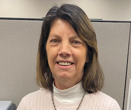 Senior woman smiling while helping older adult with paperwork at community center desk
