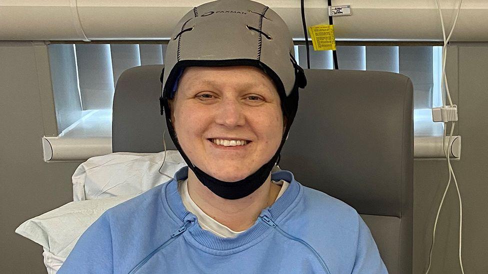 Young cancer patient Lisa using scalp cooling device during chemotherapy treatment at hospital