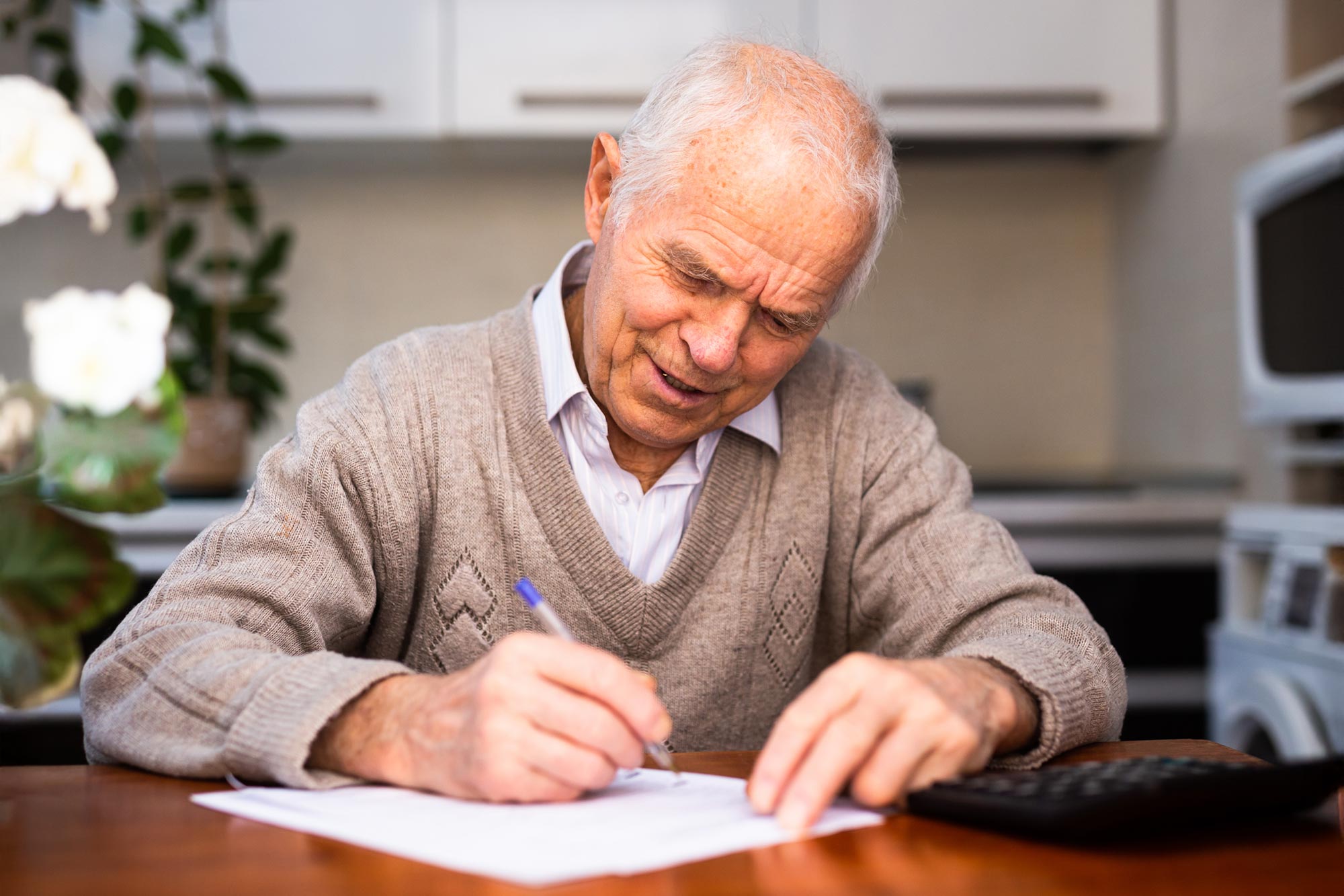 Older adult writing on digital tablet with stylus during cognitive assessment test