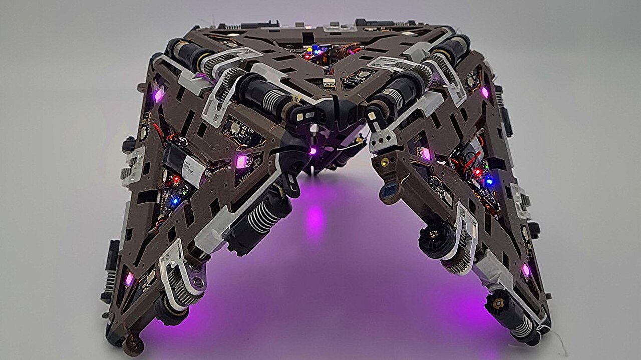Four triangular modules of the Mori3 origami robot connected together on flat surface