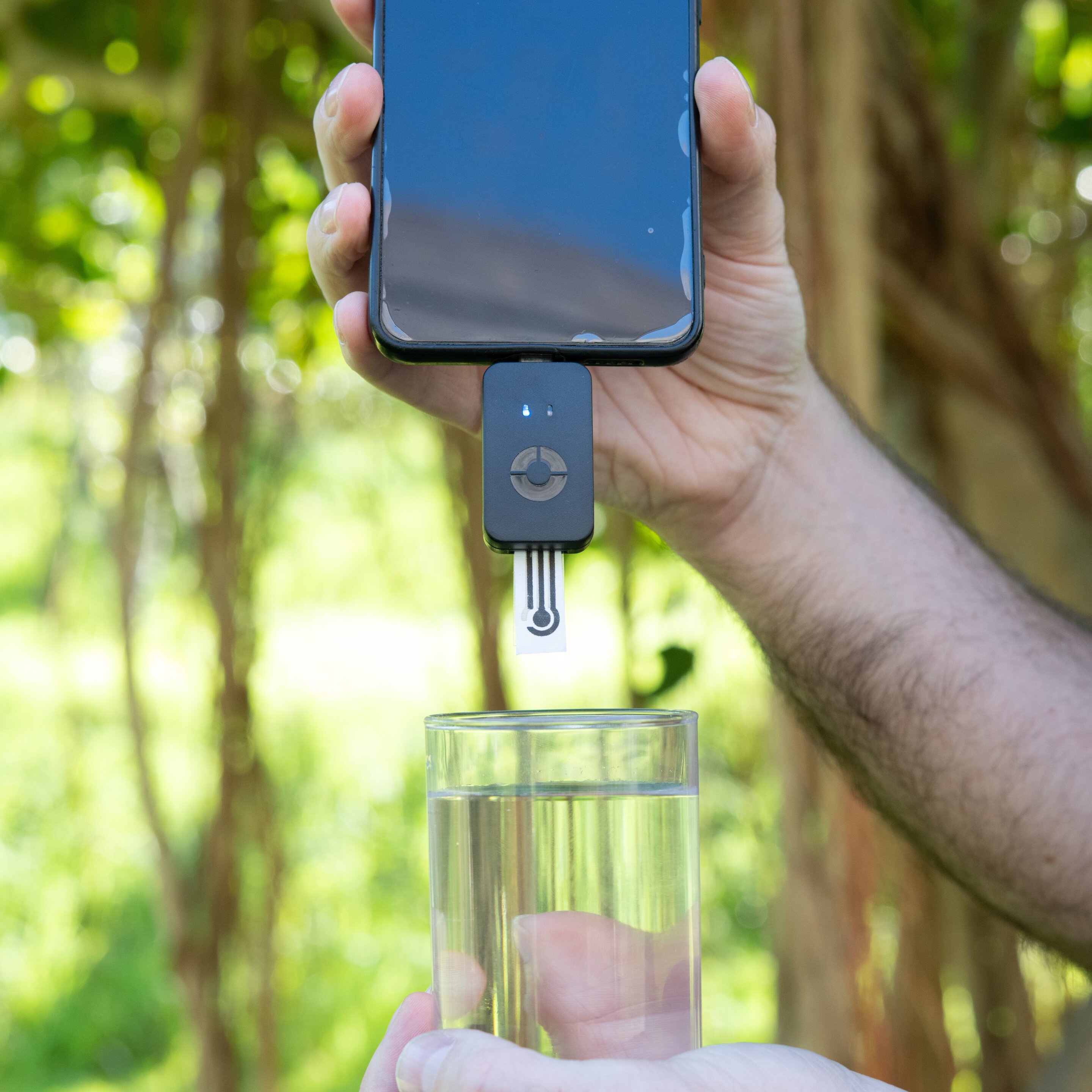 Portable PFAS detection device with fabric sensor strip inserted into smartphone dongle