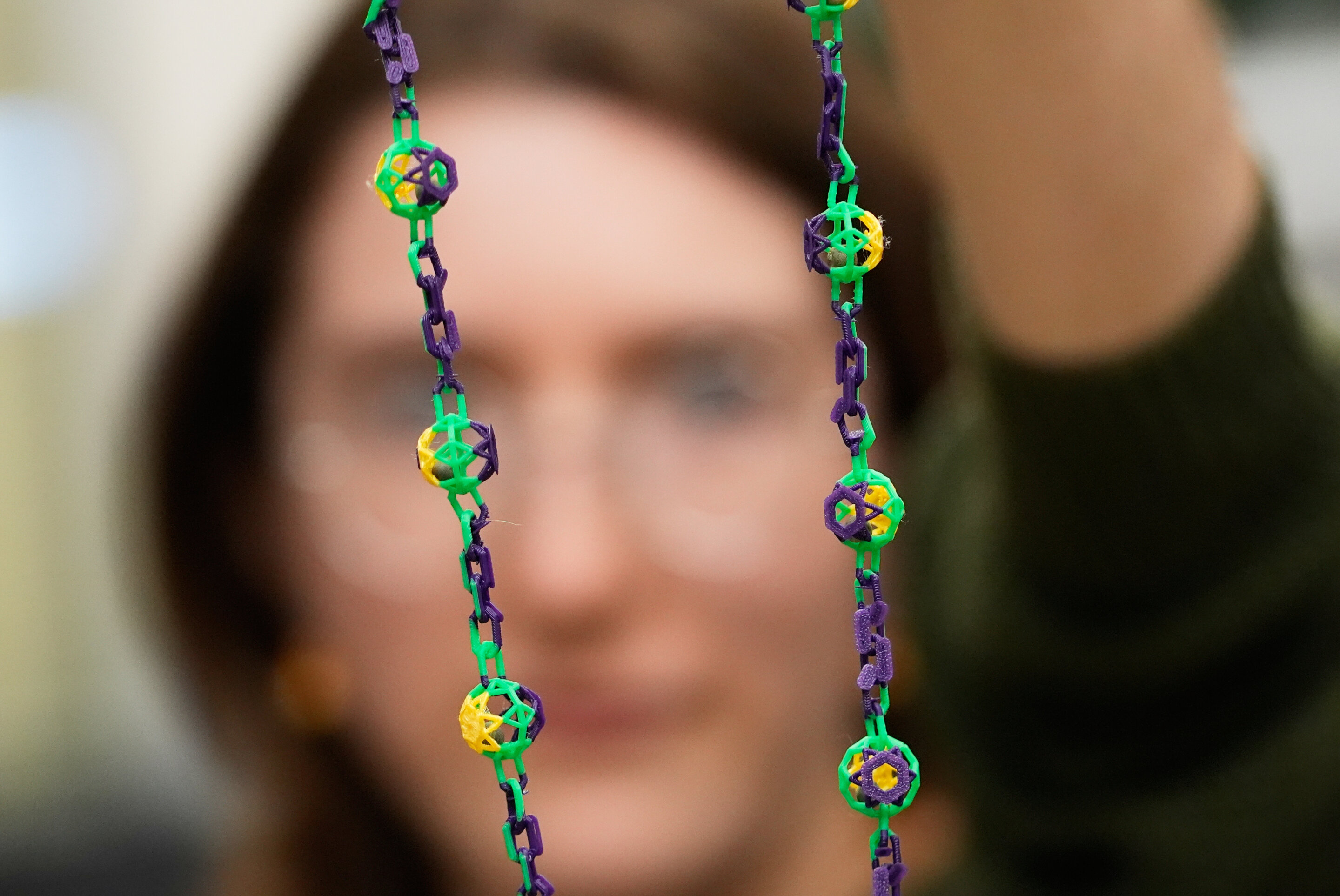 Graduate student holding large hollow biodegradable bead spheres containing seeds in LSU laboratory