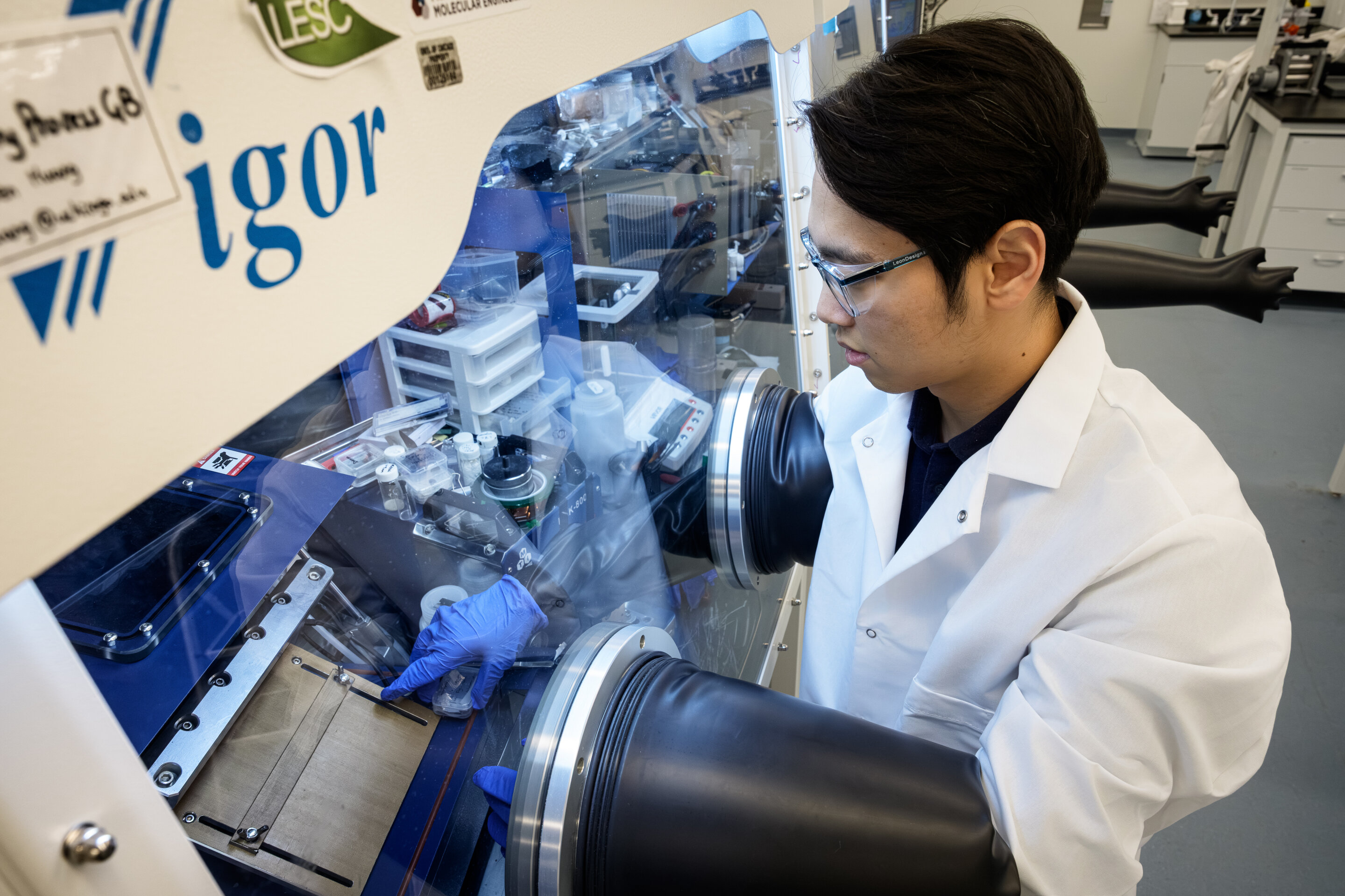 Researcher examining solid-state battery components in university laboratory setting
