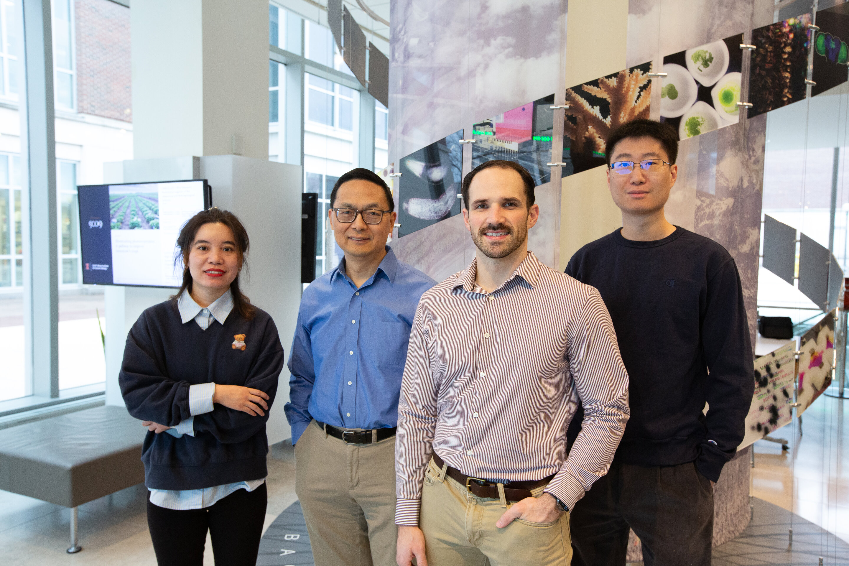 Research team members in laboratory with bioreactor equipment for light-activated bacterial production systems