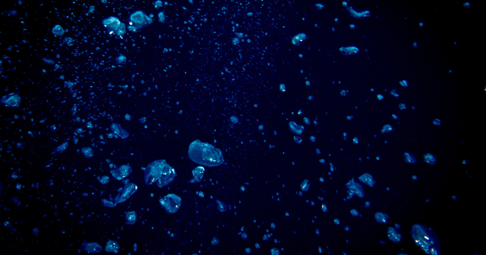 Deep ocean floor exploration submersible illuminating dark underwater terrain with bright lights