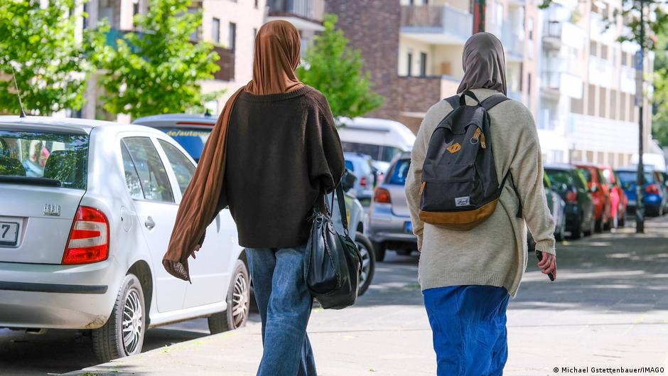 ** Diverse group of people walking through a busy German city street representing multicultural community