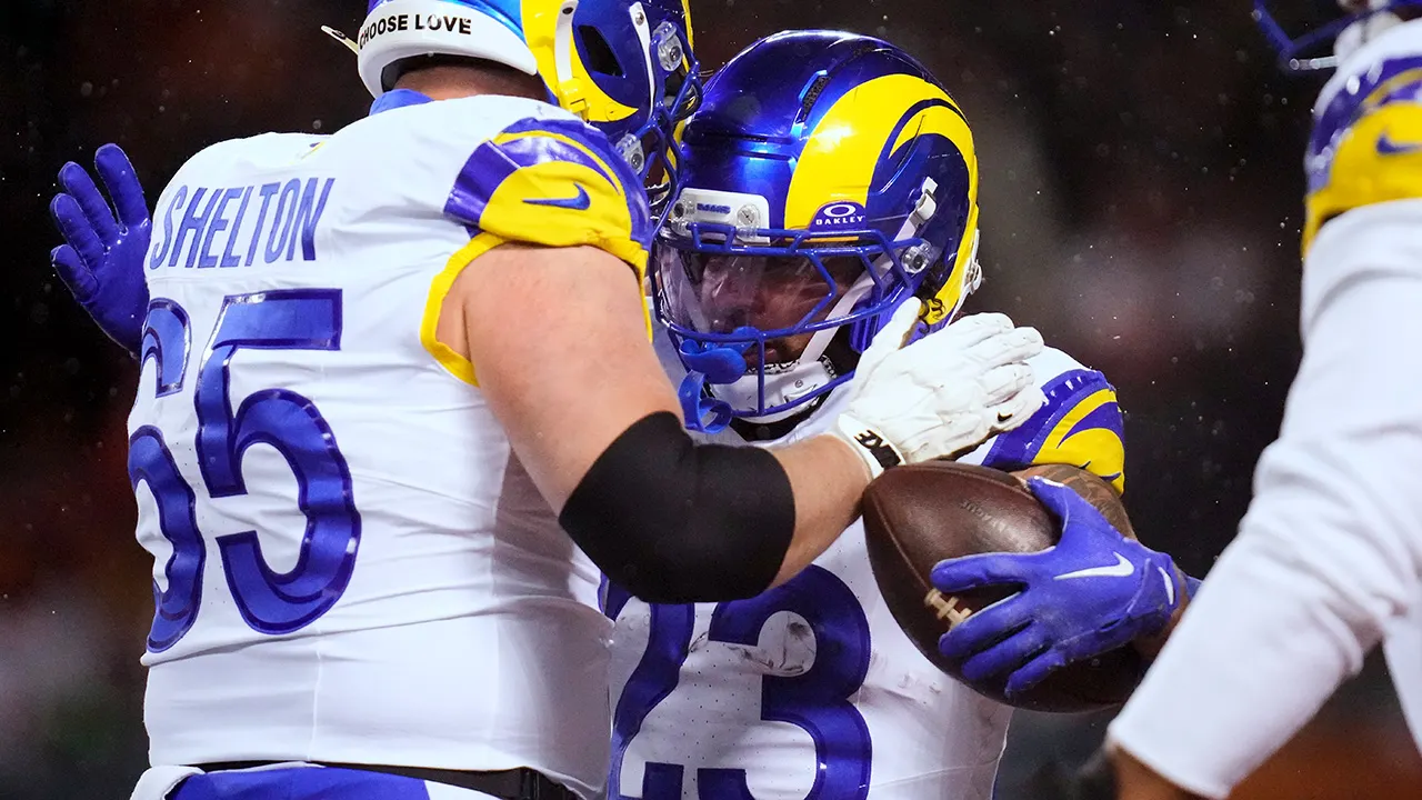 Los Angeles Rams running back Kyren Williams celebrating touchdown with teammate during playoff victory over Chicago Bears