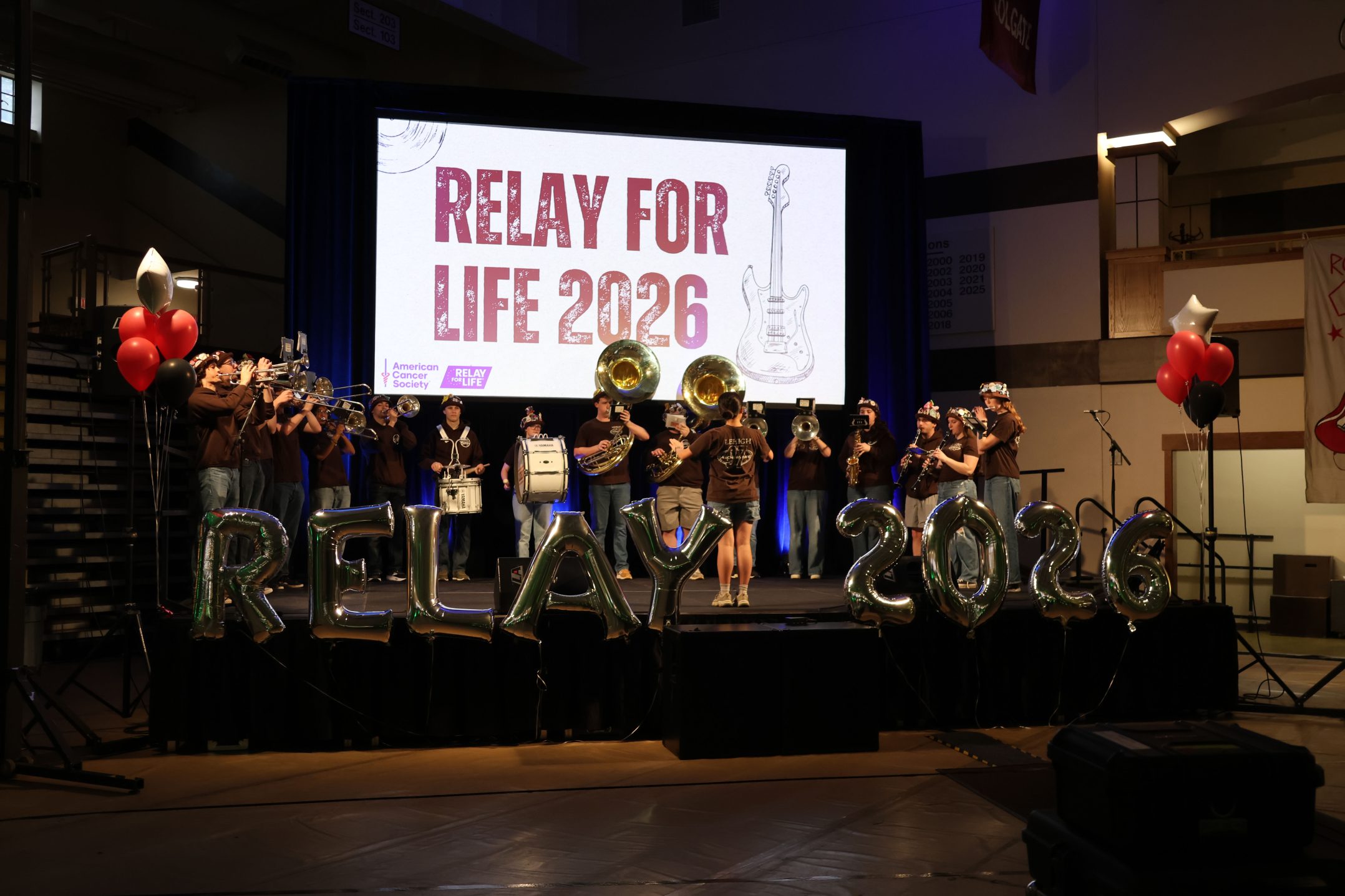 College students gathering at decorated indoor venue for cancer fundraising relay event
