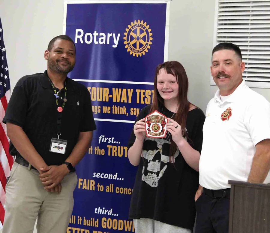 Teen Vessa Batchelor receiving Community Hero Award from Wynne Fire Chief Kory Ward and Rotary Club president