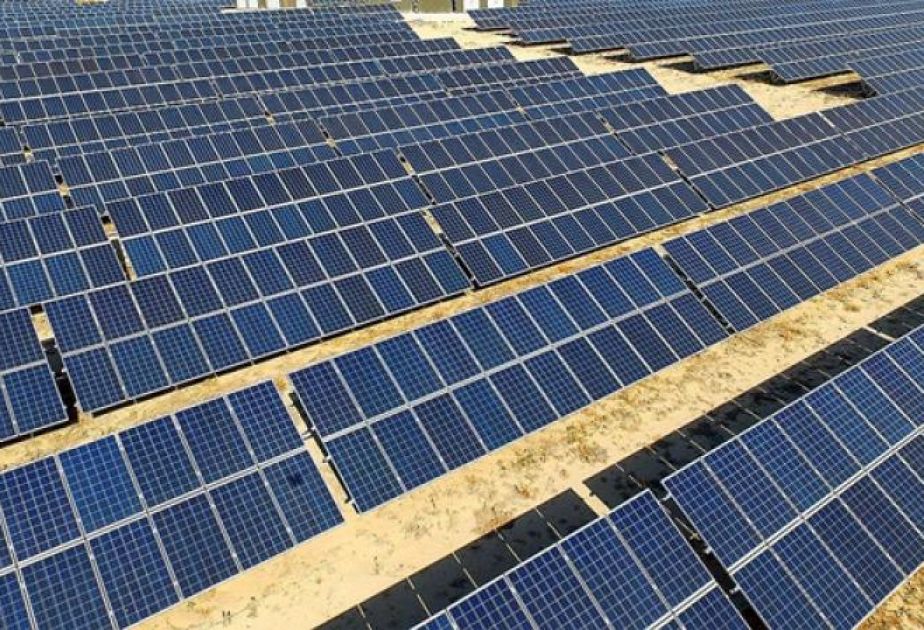 Solar panel arrays reflecting sunlight across Turkish landscape under bright blue sky